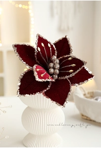 Close-up of deep red velvet Christmas flower with silver glitter and gold stamen detail