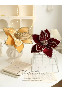 Close-up of velvet Christmas flowers with gold glitter edges in red and orange colors