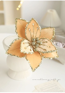 Detailed close-up of a champagne velvet Christmas flower with golden glitter sequins