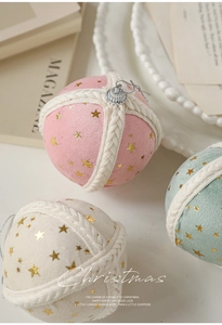 Close-up of velvet Christmas ornaments with gold stars and white rope details