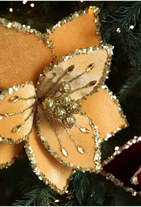 Macro shot of 26cm gold fabric Poinsettia flower with glitter petals and faux crystals