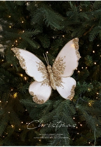 Detail of cream velvet butterfly ornament with gold sequins on a Christmas tree