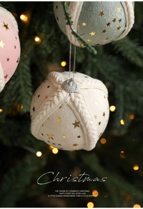 Macro detail of 8cm fabric Christmas ball ornament with gold stars and woven cord decoration