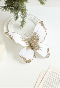 Detail view of a white velvet Christmas bow with gold sequins on decorative pine branches