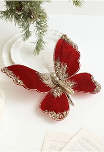 Close-up of red velvet Christmas bow with gold glitter and metal clip for tree decor
