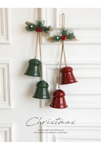 Close-up of red and green Christmas bells with pine needles and burlap ribbon on white background