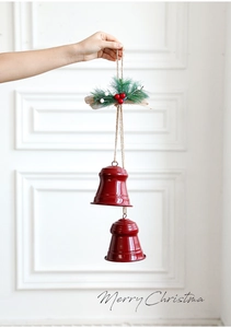 Close-up of shiny red Christmas double bells with pine needles and berries hanging decor