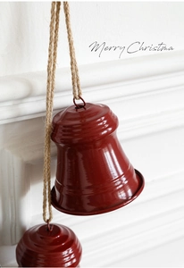 Close-up of festive red metal Christmas bells hanging on a natural jute rope string