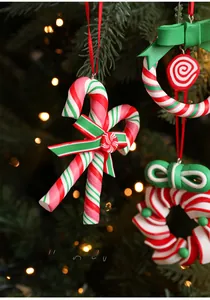 Detail of red and green candy cane and wreath ornaments hanging on a festive Christmas tree
