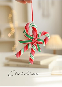 Detailed view of a red, green, and white candy cane ornament with a festive bow for Christmas