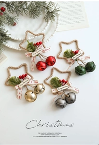 Dettaglio di stelle decorative con campanelli colorati, aghi di pino e nastri natalizi