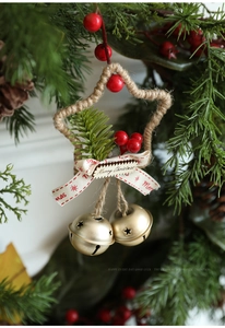 Dettaglio stella di Natale in juta con bacche rosse, fiocco e campanellini d'oro