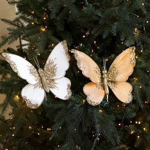 Elegant fabric Christmas bow ornaments with glitter and beads on a festive pine tree branch