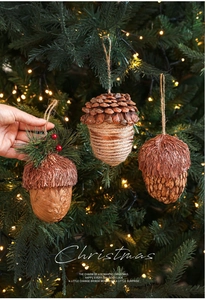 Détail de suspensions glands en bois avec aiguilles de pin et baies rouges pour Noël