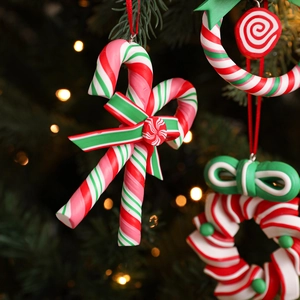 Christmas candy cane and wreath ornaments with red bows on a festive tree