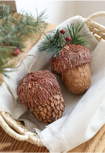 Gros plan de décorations de Noël en forme de gland en bois avec aiguilles de pin et baies