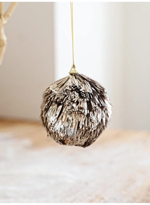Gros plan d'une boule à pompons dorés étincelante pour la décoration du sapin de Noël