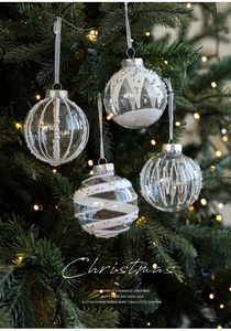 Detail of clear Christmas balls with white pearls and glitter hanging on tree
