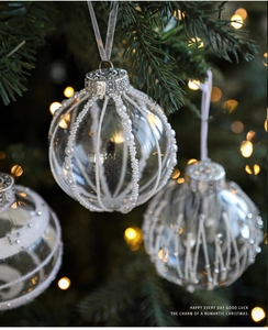Close-up of 8cm clear Christmas ball with white pearls and glitter stripe details