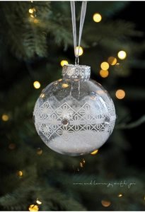 Close-up of 8cm transparent Christmas ball with white floral prints and snow filling