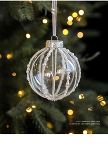 Close-up of 8cm transparent Christmas ball with white pearls and glitter on festive tree