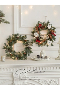 Detail of Christmas rattan wreaths with pine cones red berries and warm LED lights