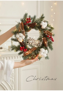 Detail of Christmas wreath with pine needles, berries, cotton, and Merry Christmas sign
