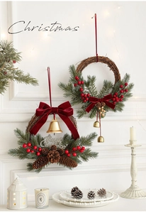 Detail of Christmas rattan wreath with red berries, pine cones and Merry Christmas sign