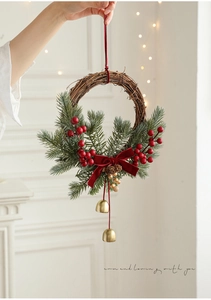 Close-up of Christmas rattan wreath with red berries, pine needles and gold bells