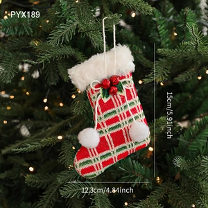 Plaid Christmas stocking ornament with faux fur trim and bells on a lit Christmas tree