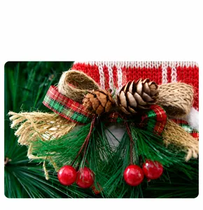 Macro detail of Christmas decoration featuring pine needles, cones and red berries.