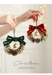 Close-up of a Christmas mini wreath with pine cones and golden Merry Christmas bow