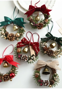 Detailed view of six mini Christmas wreaths with pine cones and festive bows