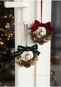 Close-up of Christmas wreaths with red and green velvet bows and metallic bells