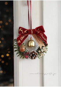 Detailed Christmas wreath with pine cones, red berries, gold bell, and velvet bow