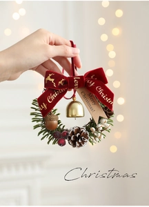 Detail of Christmas wreath with red velvet bow, gold bells, pine cones and festive berries