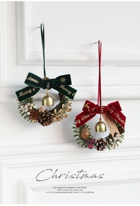 Detail of Christmas wreaths with velvet bows, pine cones, berries, and golden bells