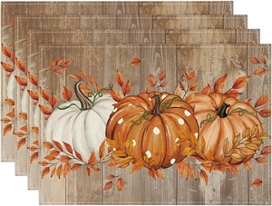 Set of four linen placemats featuring pumpkin and autumn leaf patterns for Thanksgiving