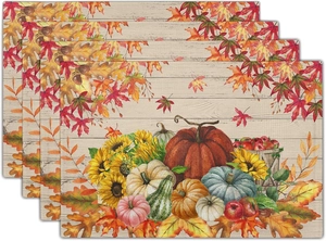 Detail of four linen place mats with pumpkins, sunflowers, and autumn harvest designs