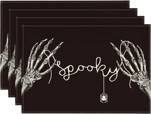 Set of 4 black Halloween placemats with white skeleton hand, spider, and Spooky text
