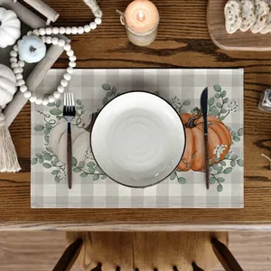 Linen Thanksgiving placemat with pumpkin and eucalyptus design on a rustic grey plaid