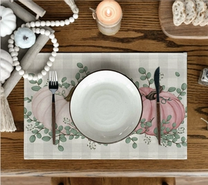 Detailed close-up of a rustic linen placemat with pumpkin and eucalyptus floral patterns
