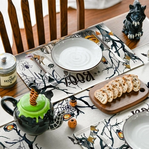 Halloween table runner and placemat set with pumpkin and ghost motifs on wooden table