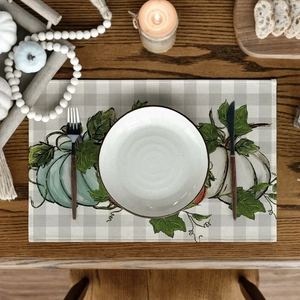 Linen placemat with pumpkin and grid pattern on wooden table for Thanksgiving