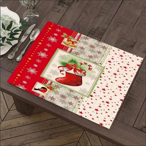 Close-up of linen placemat with Santa motifs and Christmas symbols on wood table