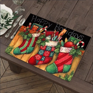 Detail of Christmas linen placemat with Happy Holidays text and festive stocking prints