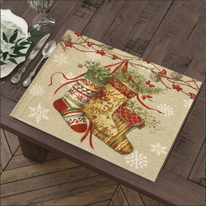 Detail of linen Christmas placemat with festive stockings and snowflakes on wooden table