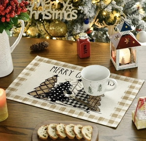 Close-up of linen Christmas placemat with snowflake tree print on dark wood table