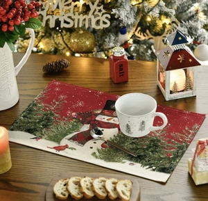 Close-up of linen Christmas placemat with snowman print on a rustic wooden table