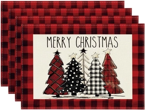 Close-up of four linen Christmas placemats with buffalo plaid edges and festive tree motifs